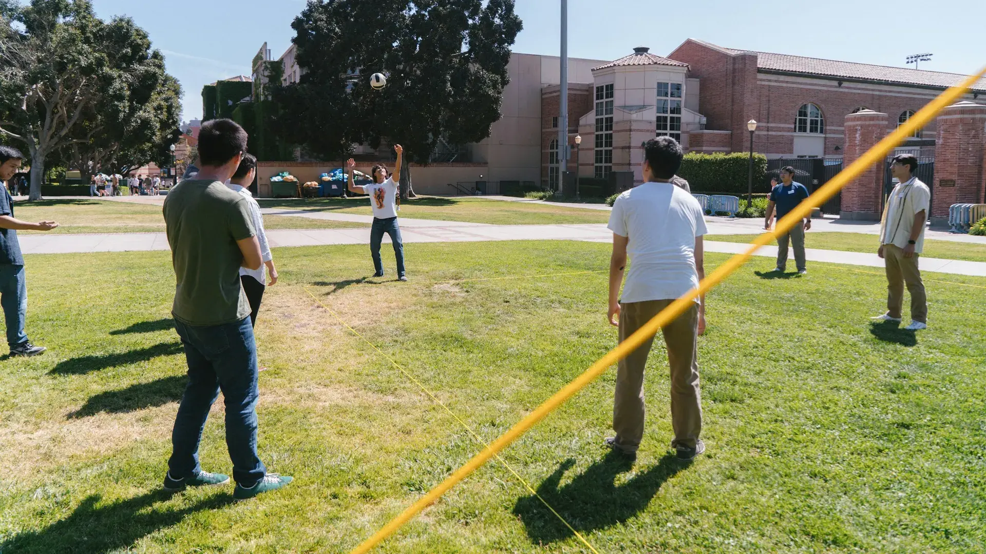 Zespół grający wspólnie w siatkówkę na świeżym powietrzu – organizacja team buildingu